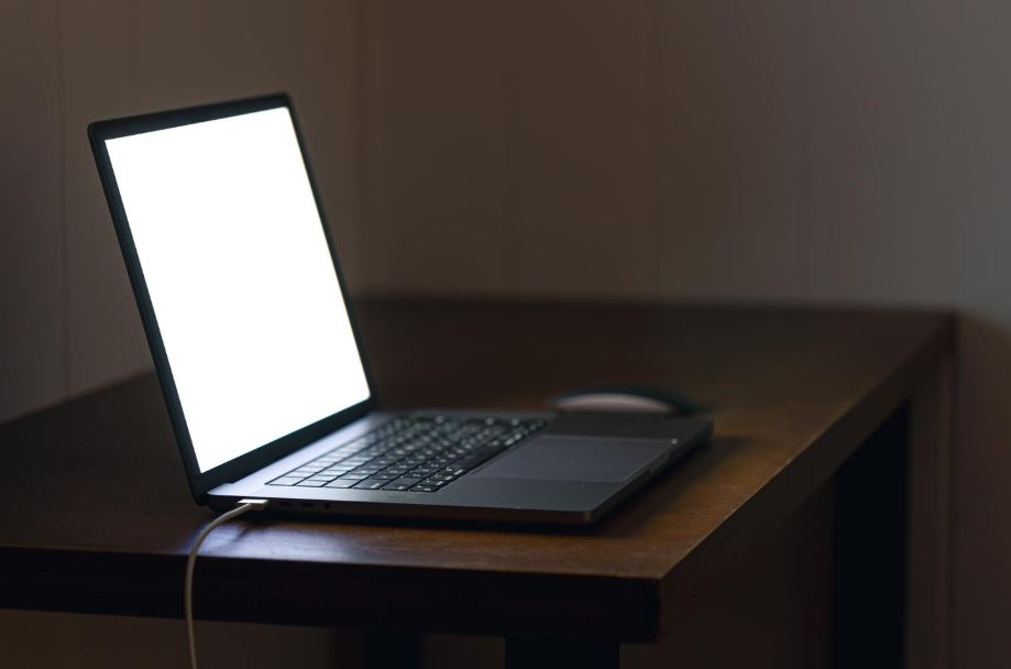 Close-up of a laptop charging with screen lit, illustrating laptop charging best practices.
