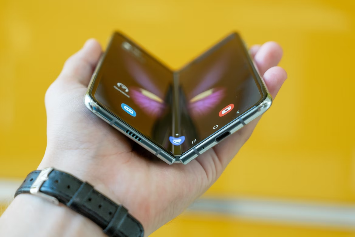 Close-up of a foldable smartphone partially closed, showing flexible display and hinge design.