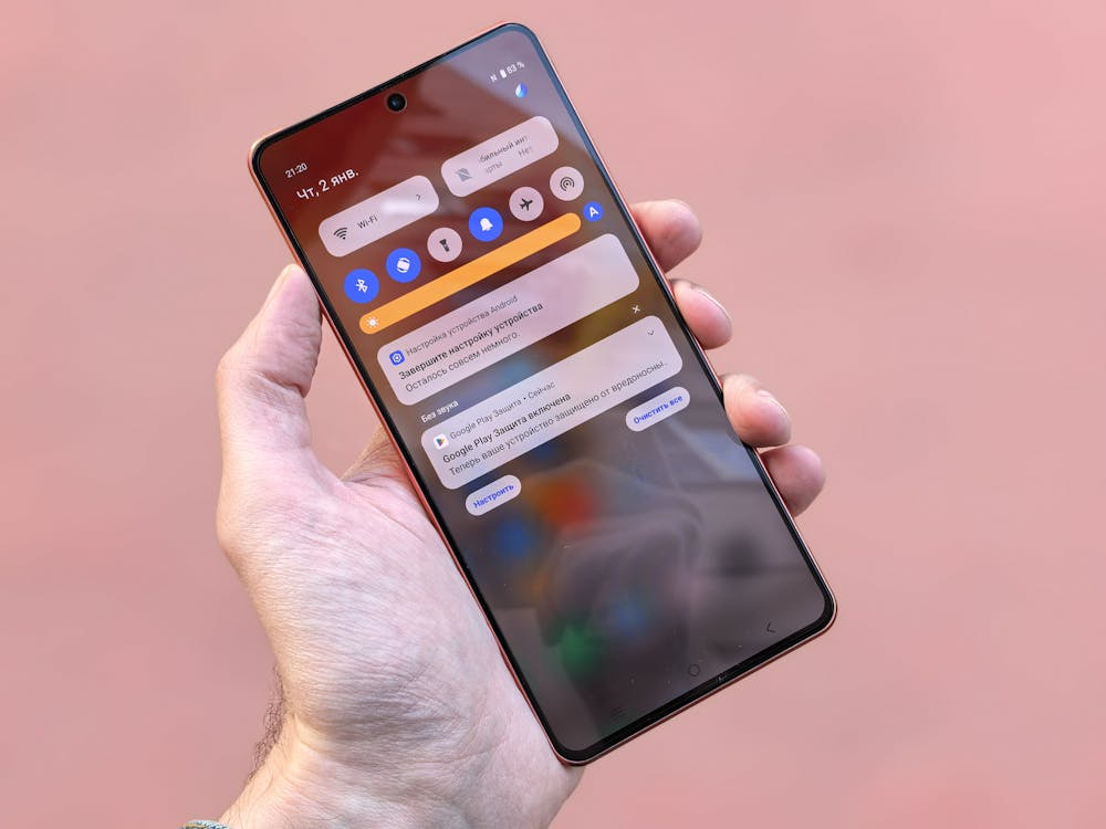 Hand holding a smartphone displaying multiple notifications on the lock screen