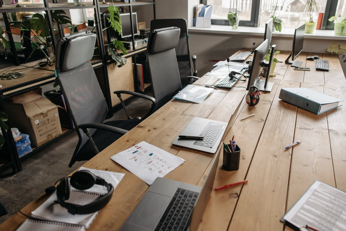 Empty office workspace with laptops and vacant chairs symbolizing tech layoffs in 2025