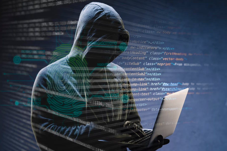Hacker in hoodie using laptop with digital code overlay symbolizing cybersecurity threats in 2025